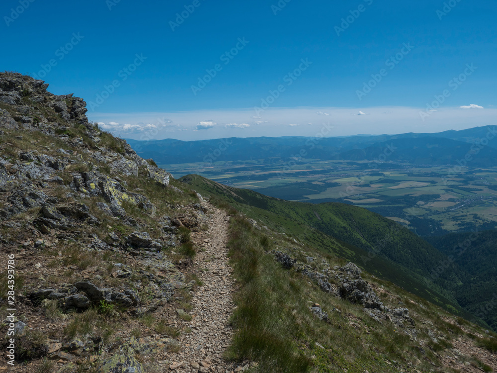 view on valley of Liptovsky Mikulas from hiking trail on Baranec peak at Western Tatra mountains or Rohace. Summer blue sky background