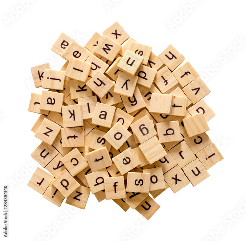 Pile of alphabet letters on wooden scrabble pieces, isolated on white background with clipping path. photo