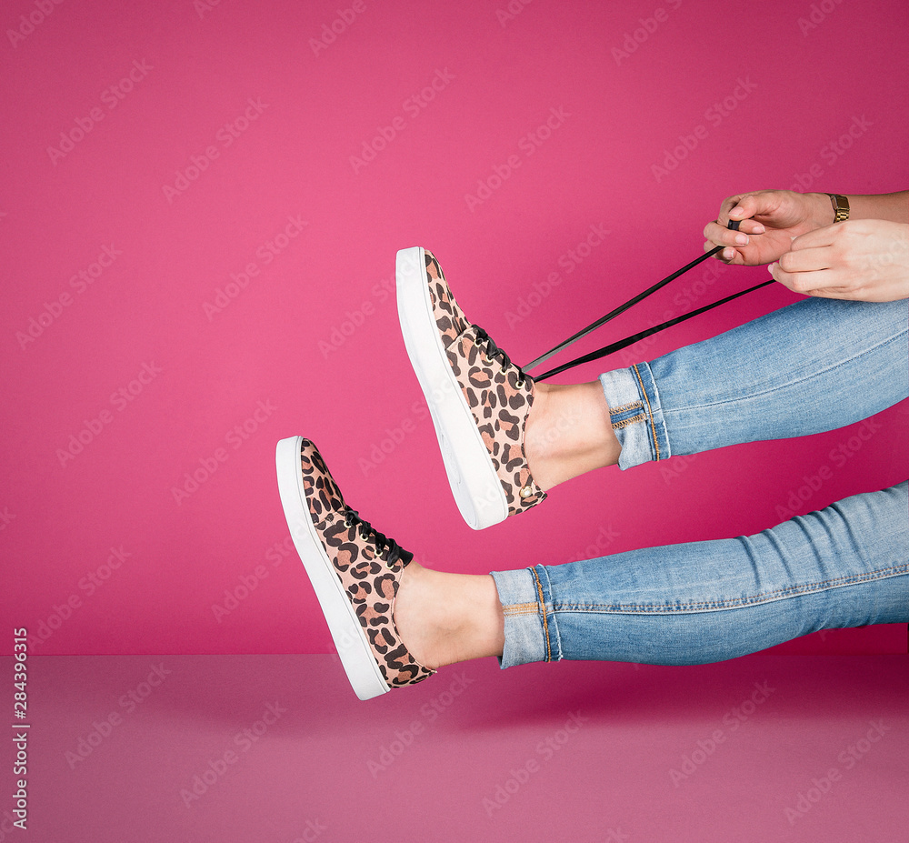 Mujer con tenis con figuras de leopardo sobre fondo de color foto de Stock  | Adobe Stock