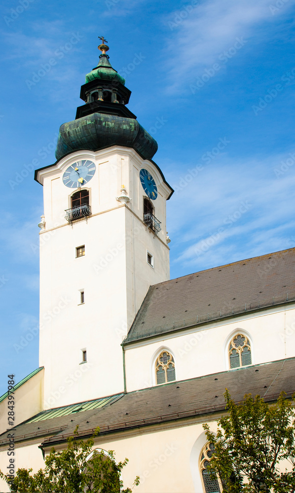 Wels, Upper Austria, Austria - Low angle view of a clock and bell tower of an old church.