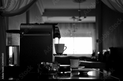 Espresso coffee machine in silhouette, view of sets when filling coffee cup.