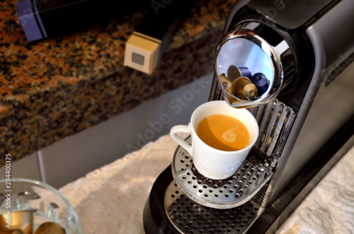 High angle view of an espresso machine with a filled cup of coffee.
