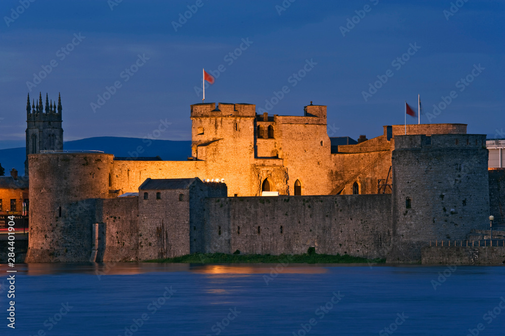 Ireland, Limerick. View of King John's Castle and the River Shannon at night. 
