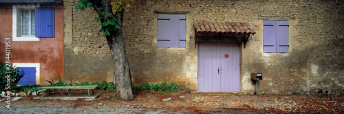 France, Cereste. Purple and blue-painted windows and doors contrast with the stone walls of these homes in Cereste, Provence, France. © Ric Ergenbright/Danita Delimont