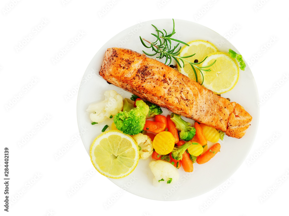 Grilled salmon fillet with vegetables, lemon and rosemary over white plate isolated, top view, overhead.