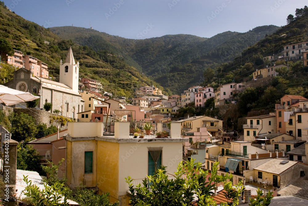 Italy, Cinque Terre, Riomaggiore. View looking eastward from town into the hills with St. John the Baptist Church on left.