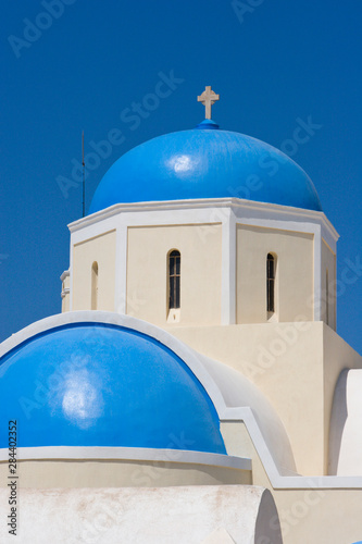 Greece, Santorini, Thira, Oia. Blue Greek Orthodox church domes against blue sky.