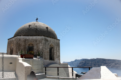 Oia, Greece. Grey dome Greek Christian Church overlooks the Caldera, white washed buildings