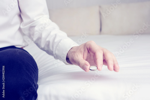 Husband takes off his wedding ring and leaves it in the marital bedroom  sitting on the bed in the home  closeup  cropped image  toned. The concept of divorce and family disintegration
