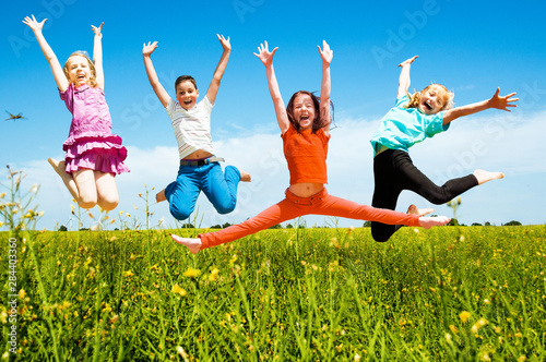 Happy active children jumping outdoors