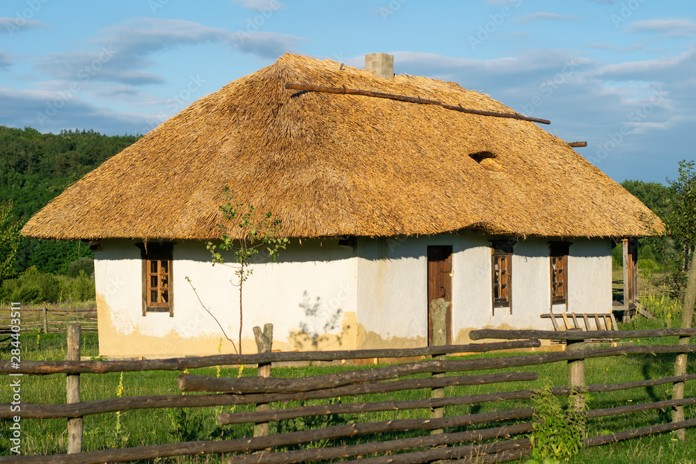 Traditional Ukrainian house. Window and door in a wooden frame. Roof made of straw Traditional Ukrainian house. Window and door in a wooden frame. Roof made of straw