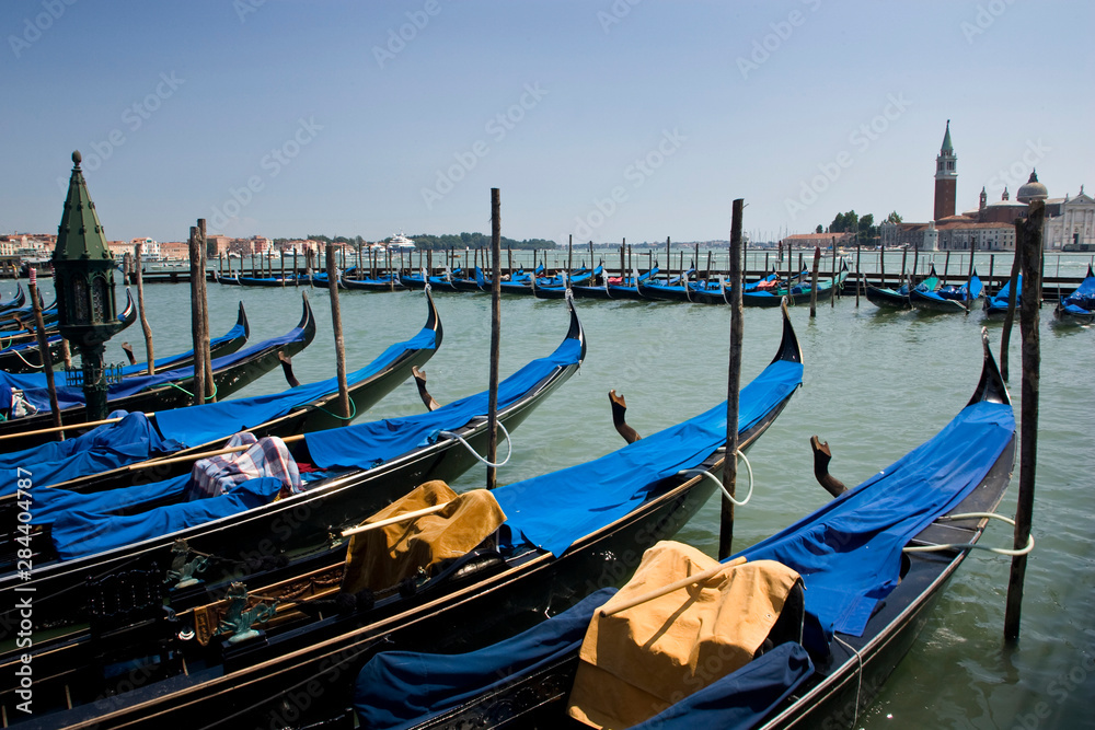Italy, Venice. A row of gondolas docked near San Marco Square.