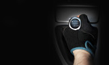 Dłoń w rękawiczce na sześcio biegowej dźwigni zmiany biegów w samochodzie osobowym, tekst.