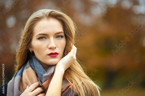 Glamor blonde girl wearing jacket  posing at the botanical garden