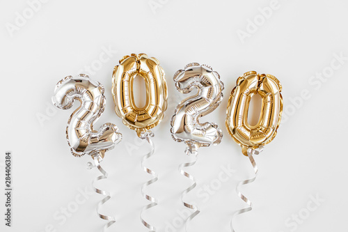 Foil balloons in the form of numbers 2020. New year celebration. Gold and silver Air Balloons. Holiday party decoration.