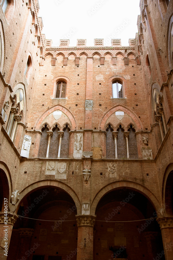 Sienna, Tuscany, Italy - Low angle view looking up from the enclosed courtyard of an old building.