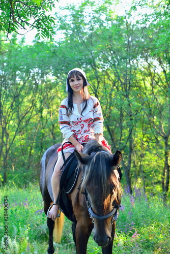 Girl in an ancient russian attire riding a horse