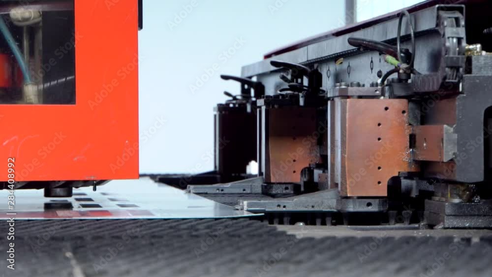 Rotation CNC punching & nibbling machine in action. Metal perforating industrial machine Rotation CNC punching & nibbling machine in action. Metal perforating industrial machine
