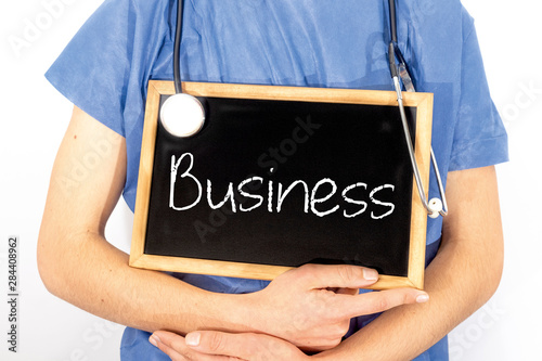 Doctor shows information on blackboard: business. Medical concept.