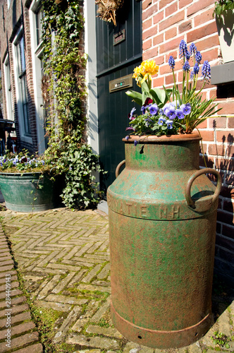 The Netherlands (aka Holland). Medieval cheese producing town of Edam. Old milk can used as flower pot. © Cindy Miller Hopkins/Danita Delimont