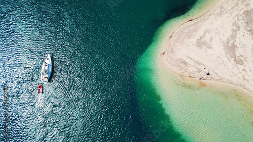 Aerial drone bird's eye view of famous and exotic sand tongue beach with clear emerald waters near castle of Santa Mavra in entrance of Lefkada island, Ionian, Greece photo