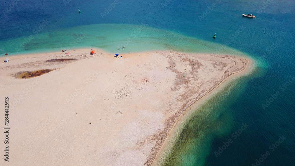 Obraz premium Aerial drone bird's eye view of famous and exotic sand tongue beach with clear emerald waters near castle of Santa Mavra in entrance of Lefkada island, Ionian, Greece