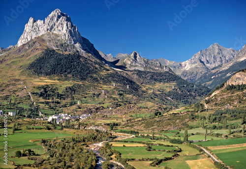 Spain  Sallent de Gallego. A small village nestles at the foot of these jagged peaks near Sallent de Gallego in the Pyrenees Mountains  Spain.
