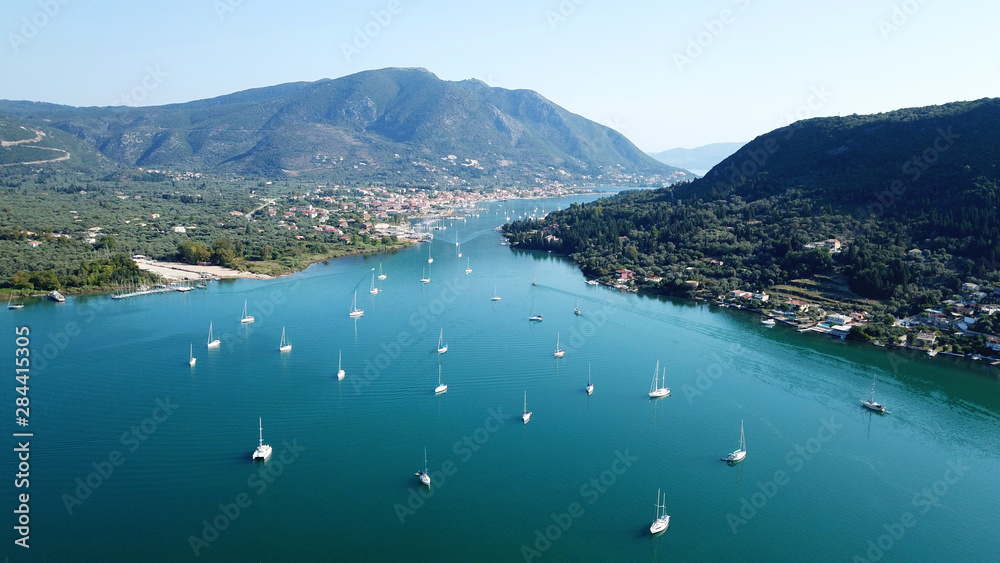 Aerial drone bird's eye view photo of iconic port of Nidri or Nydri a safe harbor for sail boats and famous for trips to Meganisi, Skorpios and other Ionian islands, Leflkada island, Ionian, Greece