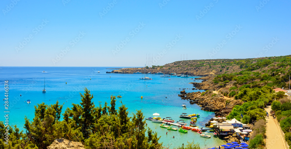  blue sea with clear water, mountains, yachts and the beach on the panorama of Konnos Bay Cyprus