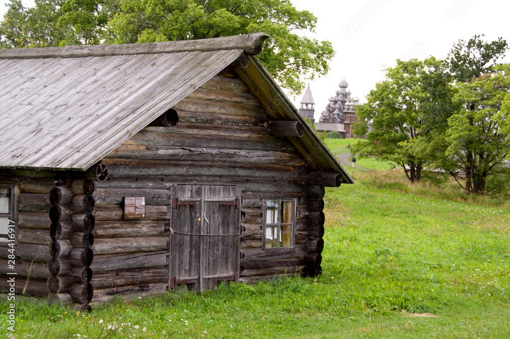 Russia, Lake Onega, Kizhi Island. Historic home with 22-domed Transfiguration Churc, built in 1714 without a single nail, in distance. UNESCO site. Russia, Lake Onega, Kizhi Island. Historic home with 22-domed Transfiguration Churc, built in 1714 without a single nail, in distance. UNESCO site.