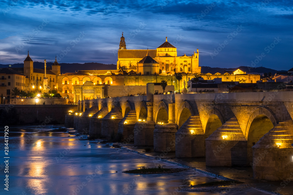Spain, Andalusia. Cordoba. Roman bridge across the Guadalquivir river at dusk.