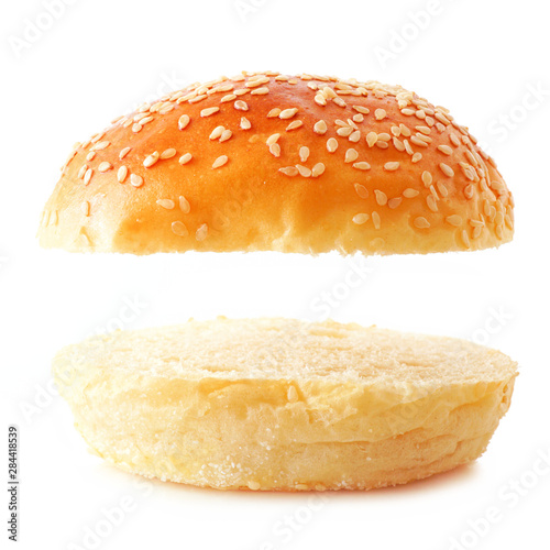 Open sesame seed hamburger bun on a white background. Top and bottom isolated with copy space. photo