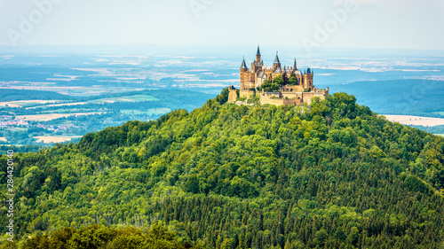 Hohenzollern Castle on mountain top, Germany. This castle is a famous landmark in vicinity of Stuttgart. Scenic panorama of Burg Hohenzollern in summer. Landscape of Swabian Alps with Gothic castle. photo
