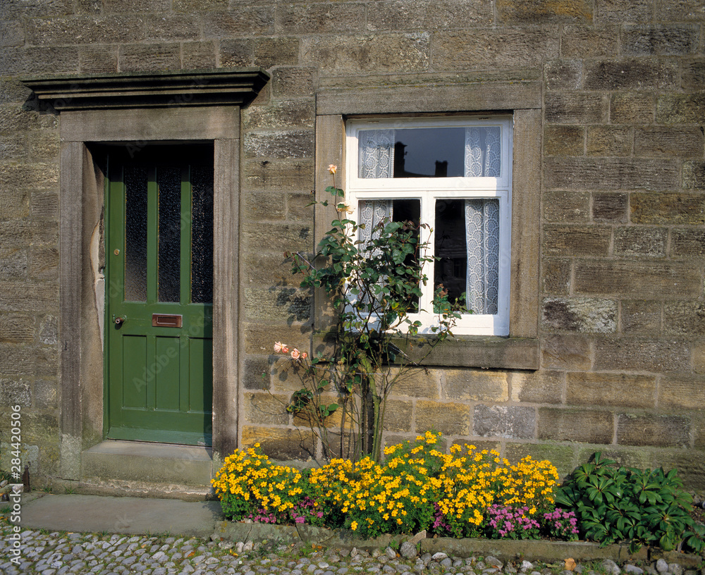 England, Grassington. A green door is the perfect companion to a white paned window in Grassington, Yorkshire Dales NP, England.