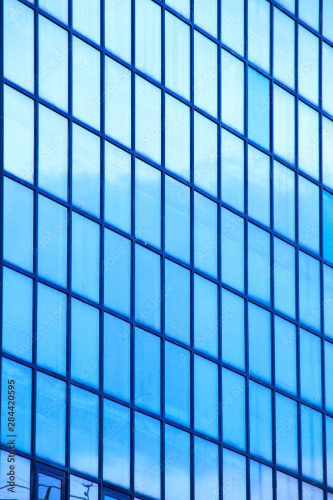 A high-rise office building with blue glass windows A high-rise office building with blue glass windows