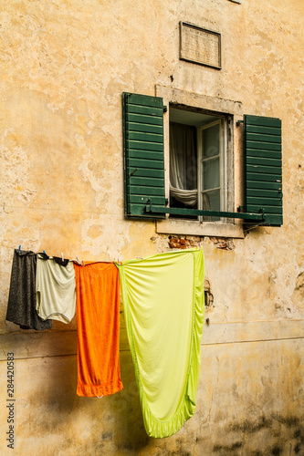 Kotor, Montenegro. Colorful hanging laundry, green shutters, and an open window © Jolly Sienda/Danita Delimont