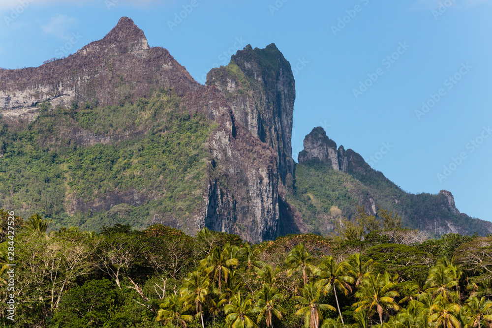 Pacific Ocean, French Polynesia, Society Islands, Leeward Islands, Bora Bora. View of extinct volcano and peaks of Mount Otemanu and Mount Pahia above palms.