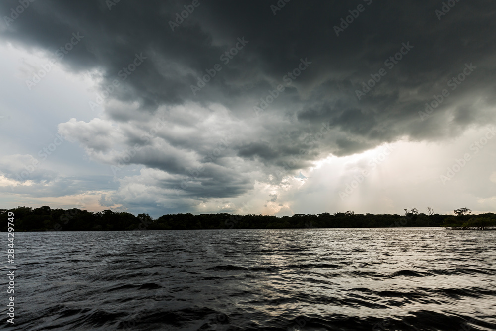 A dark thunderstorm cloud moves above the Amazon River near Manaus, Brazil