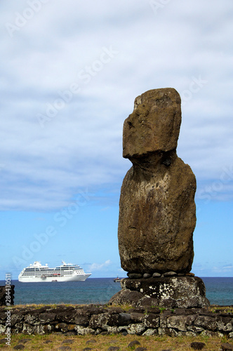 Chile, Easter Island (aka Rapa Nui), Hanga Roa. Traditional Moai with Pacific Princess cruise ship in distance.