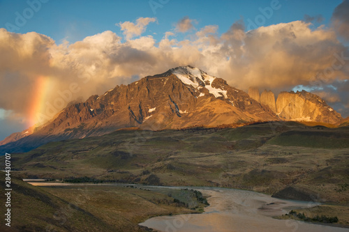 Chile, Torres del Paine National Park. Sunrise rainbow lights mountain with the Rio Paine in the foreground.  © Jaynes Gallery/Danita Delimont