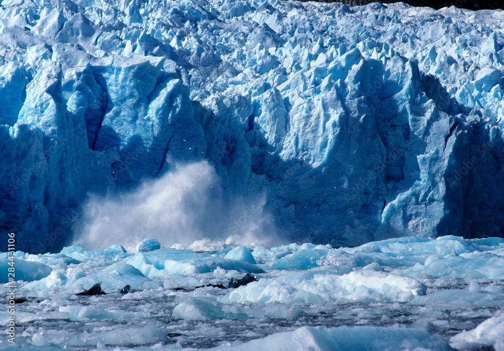 Chile, San Rafael Lagoon NP. A newly-calved iceberg splashes against the icy foundations of San Rafael Lagoon NP, Chile.