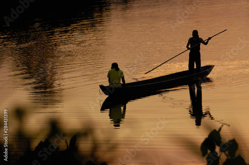Foto Quichua Indians poling dugout canoe on jungle lake