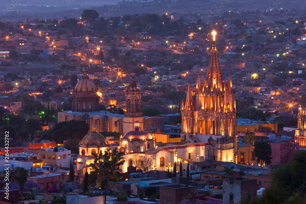 Naklejka premium Meksyk, San Miguel de Allende. Kościół La Parroquia de San Miguel Arcangel dominuje nad miastem o zmierzchu.