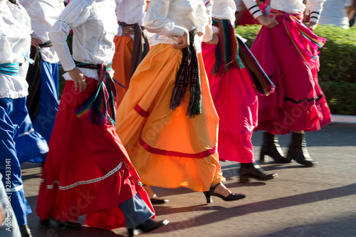 Mexico, Yucatan, Merida, dancers with swirling skirts in parade (lower torsos)