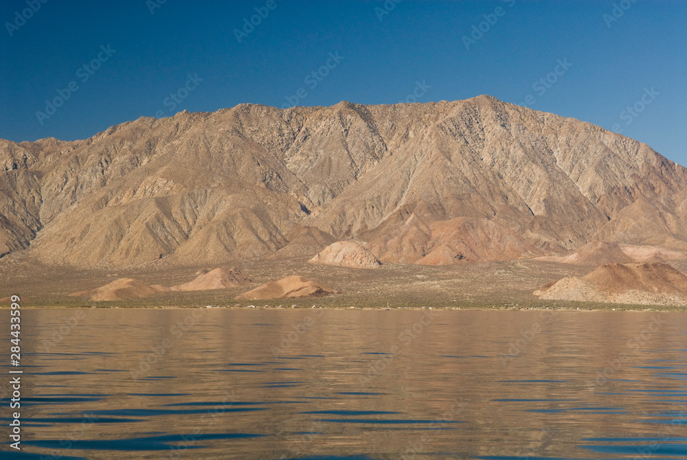 Mexico, Baja California, Bahia de los Angeles. Calm waters reflect mountains. Less development in Midriff Islands regions than Baja California South. Renown for whale sharks and fishing.