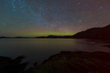 US, Alaska, Ketchikan. Northern Lights glow on horizon with star trails. Settler's Cove State Park.