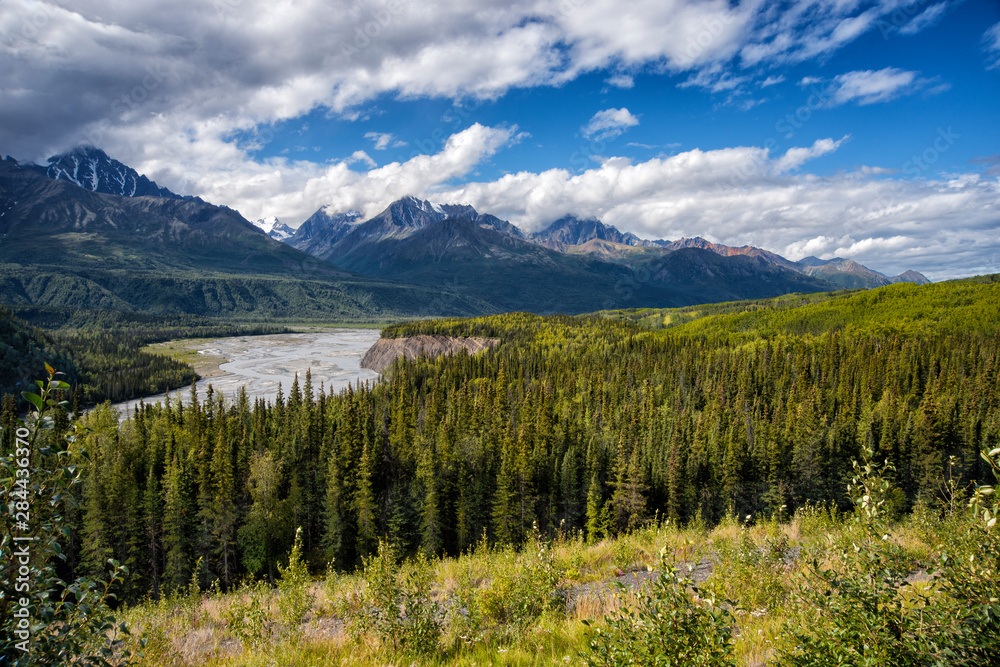 Glacial water melt river in valley in mountain range in Alaska