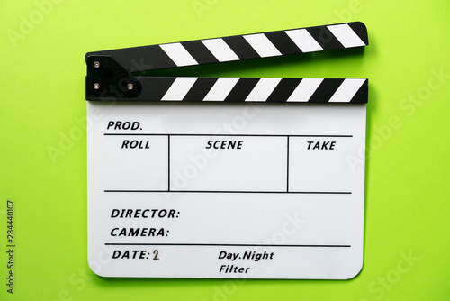 Tela movie clapper on green table background ; film, cinema and video photography con