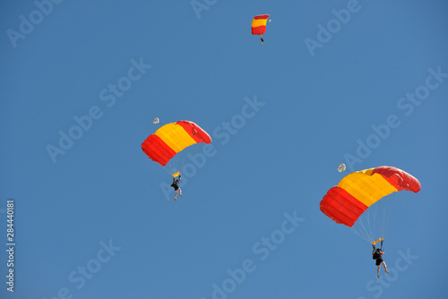 Obraz na plátně USA, Arizona, Eloy, people skydiving with orange and red parachutes