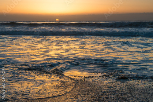 USA, California, Jalama Beach State Park. Sunset with out-going swirling tide photo